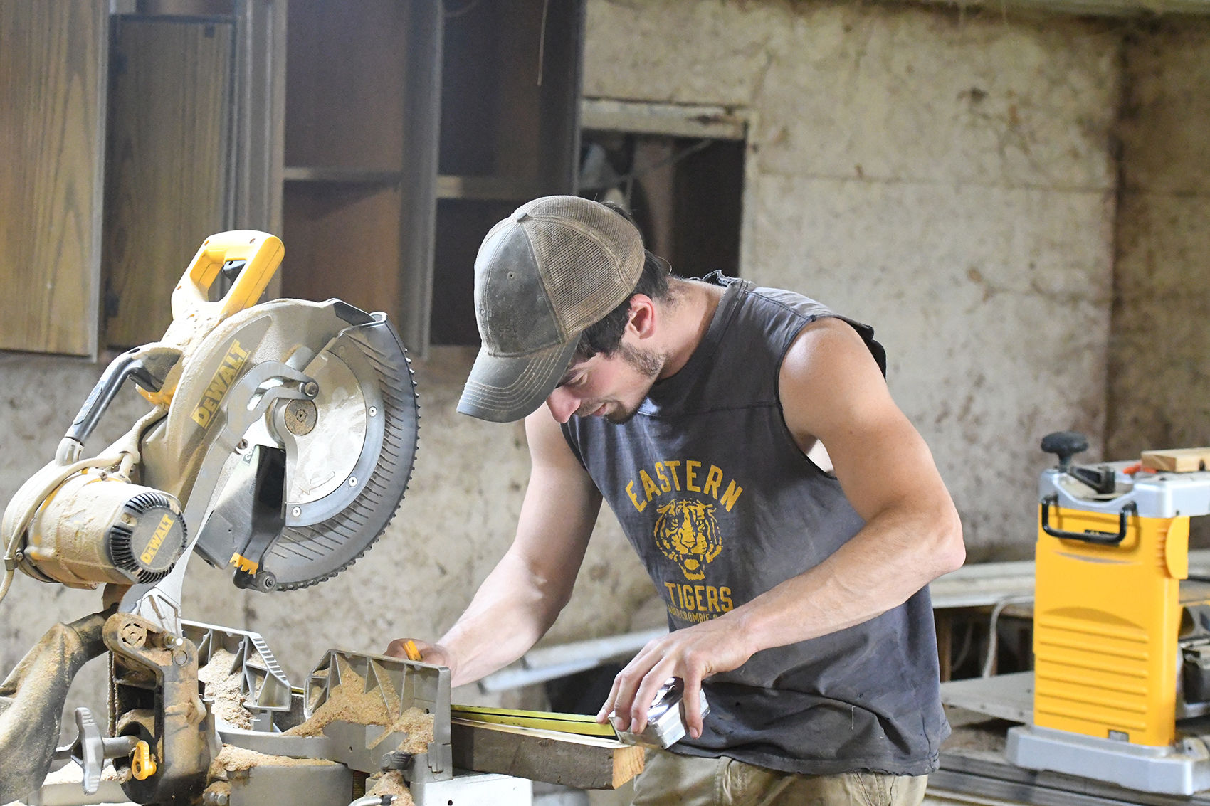 Benji Moser measures barnwood piece